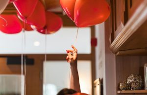 Kako izabrati dekoraciju za dečji rođendan? ruka-crveni-baloni-vrpca