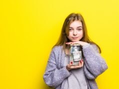 Kako izabrati deviznu štednju koja donosi više od privlačne reklame? Devojka drži teglu sa novcem kao simbol devizne štednje