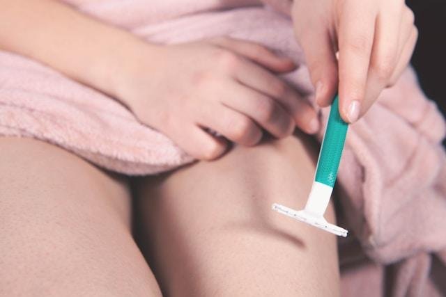 Žena brije nogu brijačem Žena brije nogu brijačem kao deo nege kože