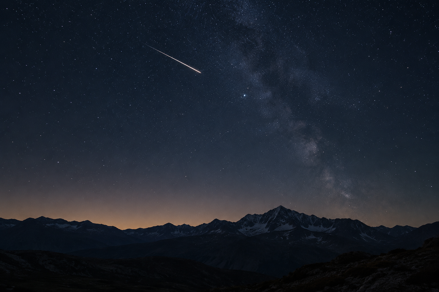 Tanak svetlosni trag meteora iznad planinskog horizonta na zvezdanom noćnom nebu.